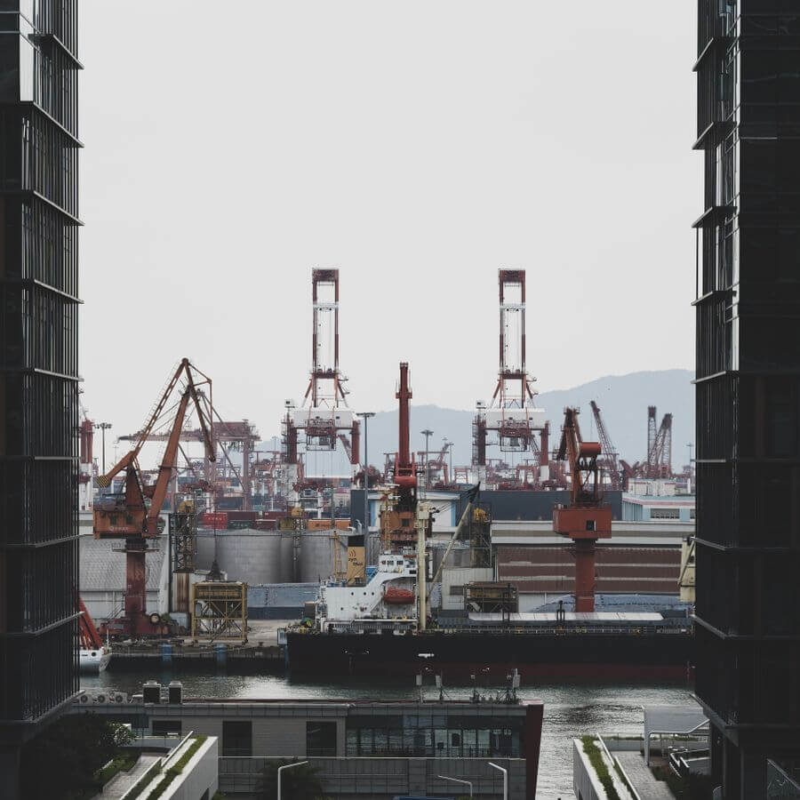 Port terminal with gantry cranes and stacked cargo at the quay